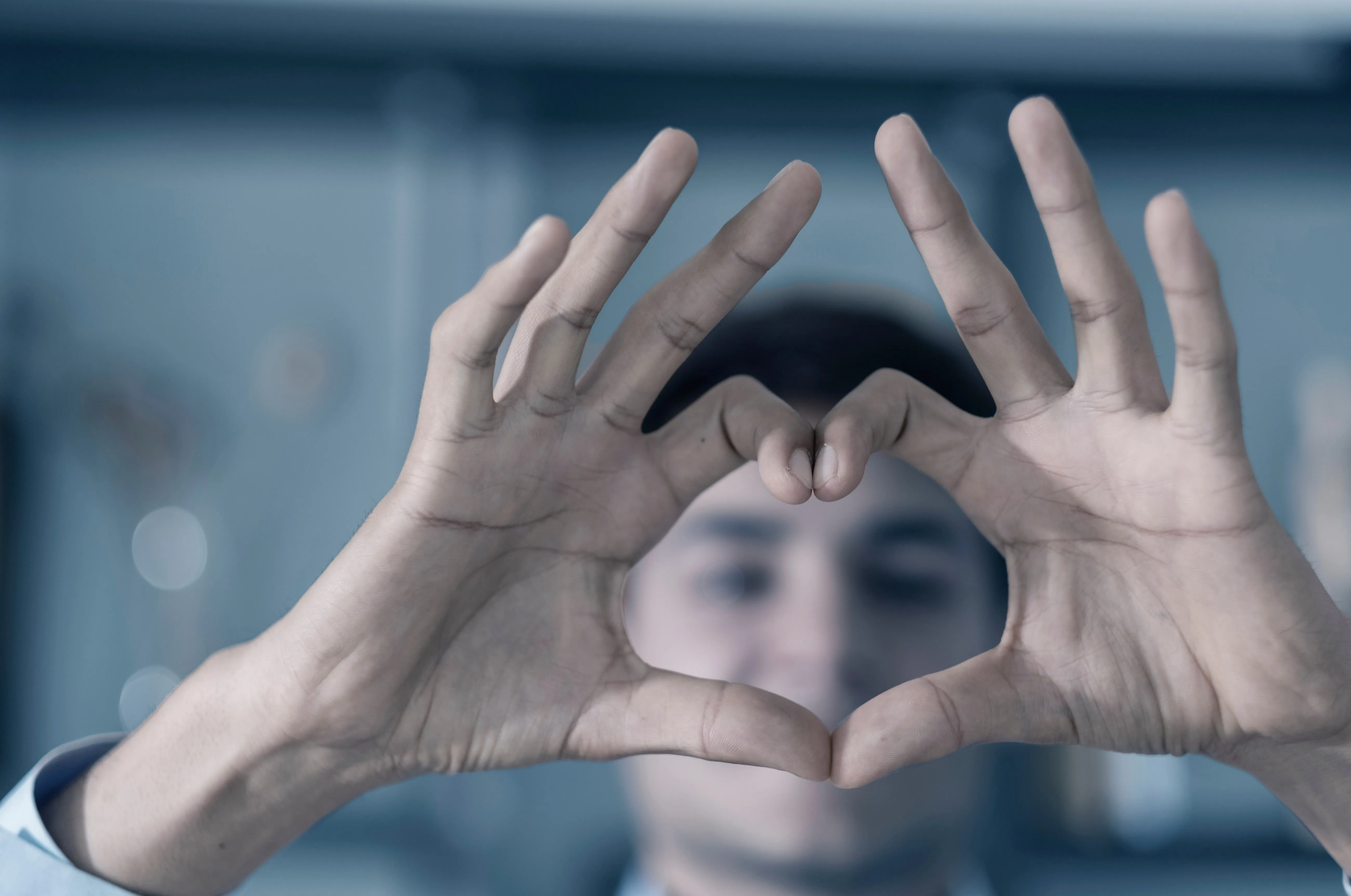 A close view of a client's hands held up in the heart gesture
