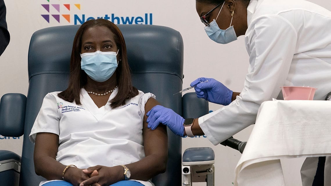 Sandra Lindsay, an intensive care nurse at Long Island Jewish Medical Center in Queens, received the coronavirus vaccine during a news conference with Gov. Andrew Cuomo. Pool photo by Mark Lennihan featured in NY Times